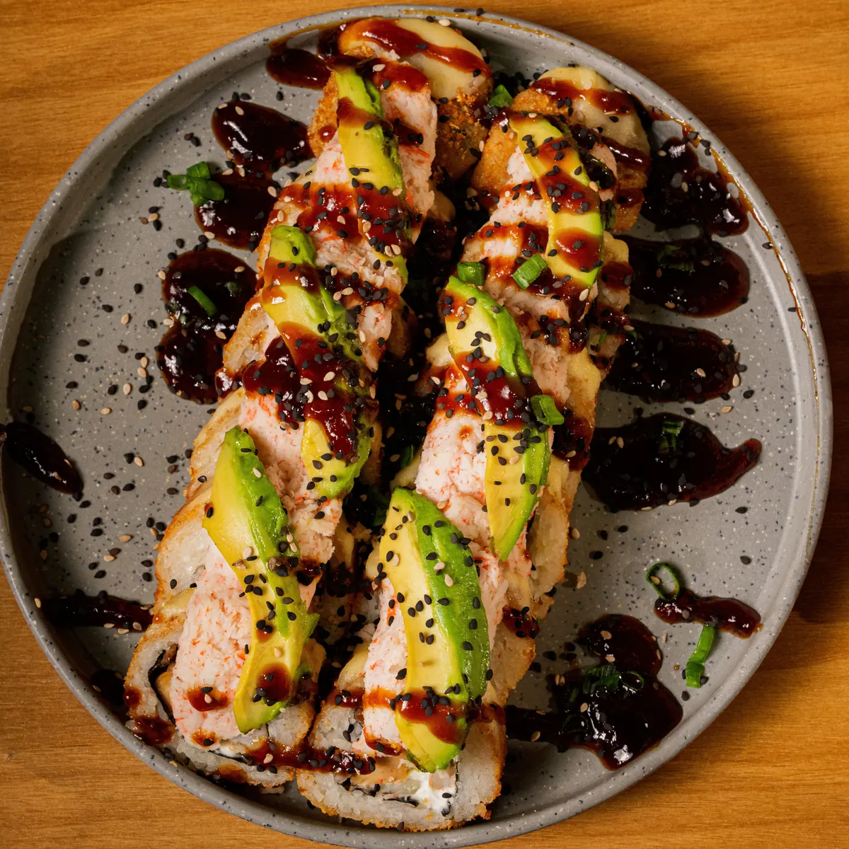 Rollo Bélico gratinado con tampico, aguacate y salsa de anguila